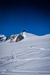 Scenic view of snowcapped mountains against clear blue sky