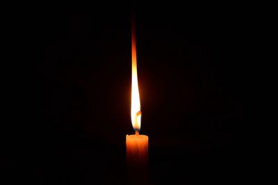 Close-up of illuminated candle in darkroom