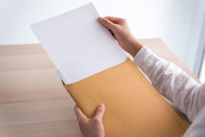 Cropped hand of woman holding book