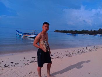 Full length portrait of man on beach against sky