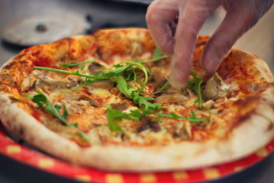 Close-up of hand holding pizza