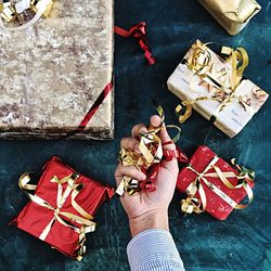 Cropped image of man holding ribbon over table during christmas