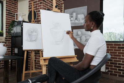 Side view of woman using laptop at home