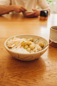 Midsection of person preparing bread in bowl on table