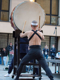 Rear view of man holding umbrella at music concert