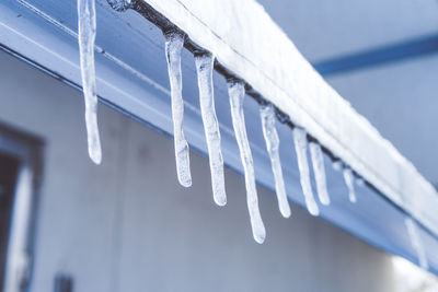 Close-up of icicles against blue sky