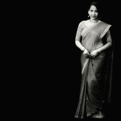 Portrait of woman standing against black background