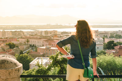 Rear view of young woman looking at cityscape