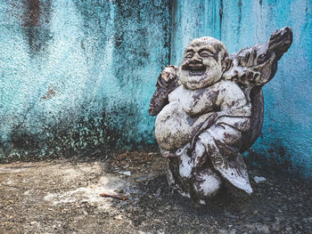 Close-up of old statue against wall