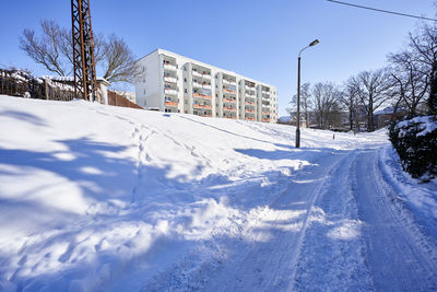 Snow covered trees and buildings against sky