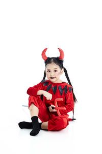 Portrait of girl wearing mask against white background
