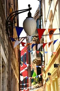 Low angle view of lanterns hanging by building