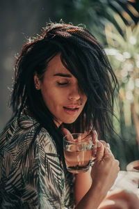 Portrait of young woman drinking water