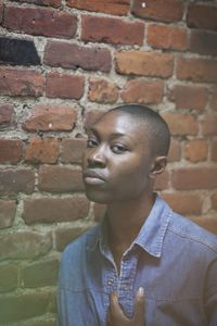 Portrait of teenage boy against brick wall