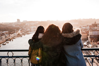 Three happy friends porto bridge sightseeing at sunset. travel, friendship and lifestyle