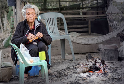 Old women sit by the fire and drink hot water in winter.