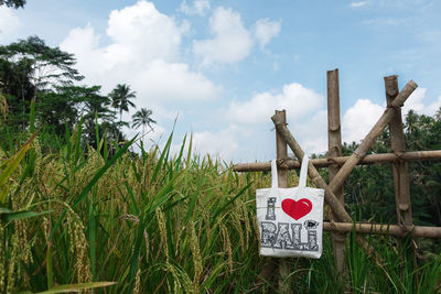 Information sign on wooden post against sky