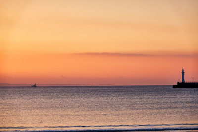 Scenic view of sea against orange sky