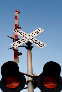 Low angle view of road sign against clear sky