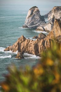 Scenic view of rocks on beach against sky