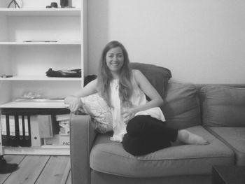 Portrait of young woman sitting on sofa