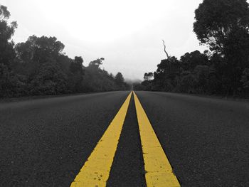 Road amidst trees against clear sky