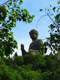 Low angle view of tian tan buddha against sky