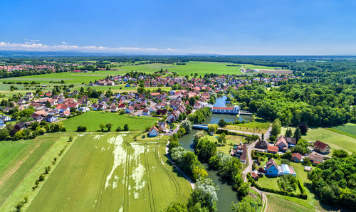 High angle view of trees and houses on field against sky