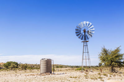 Low angle view of windmill against clear blue sky