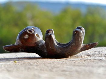 Close-up of wooden figurine on retaining wall