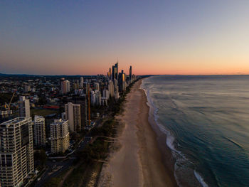 Panoramic view of sea and buildings against sky during sunset