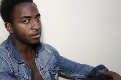 Close-up portrait of serious young man against white background