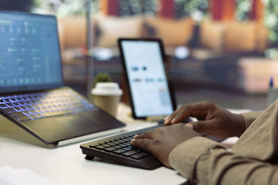 Midsection of woman using laptop on table