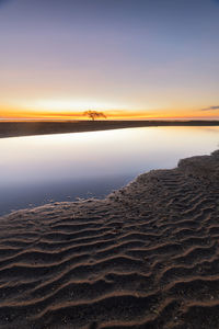 Scenic view of beach against sky during sunset