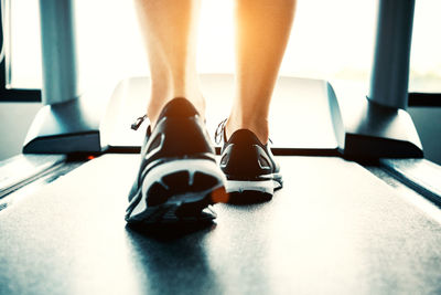 Low section of woman on treadmill in gym