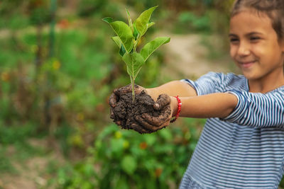 Portrait of woman holding plant