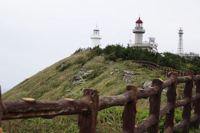 View of lighthouse against building and sky