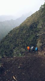 Rear view of people on mountain against sky