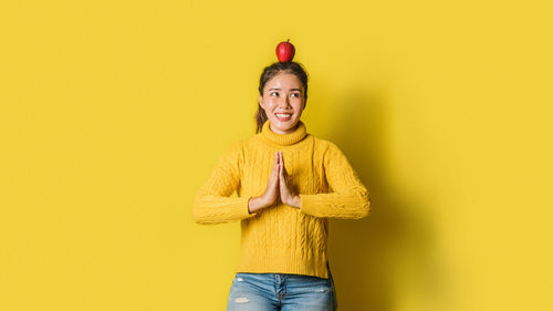 Portrait of smiling man standing against yellow background