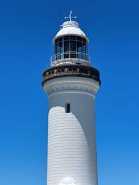 Low angle view of lighthouse against clear blue sky