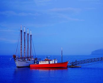 Ship moored at harbor against blue sky