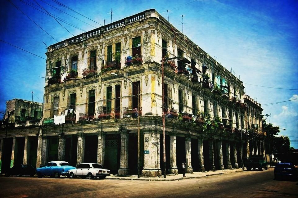 building exterior, architecture, built structure, car, transportation, land vehicle, street, blue, sky, mode of transport, road, parking, sunlight, city, stationary, outdoors, day, parked, in a row, building