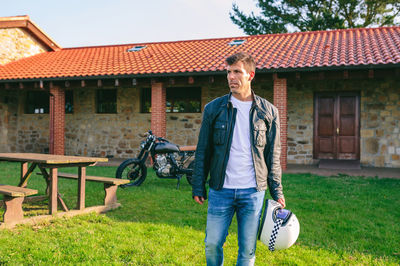 Full length of man standing on field against building