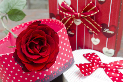 Close-up of red roses with gift boxes on table