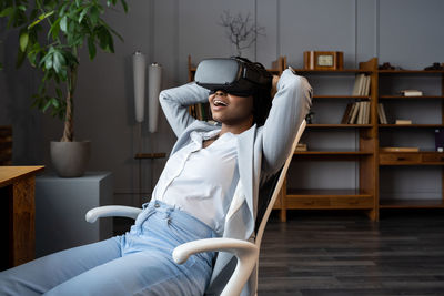 Amazed black businesswoman using vr in workplace, resting in relaxing virtual environment in office