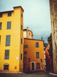 Low angle view of yellow house against sky