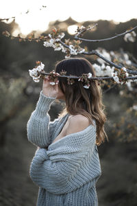 Rear view of woman holding umbrella standing outdoors