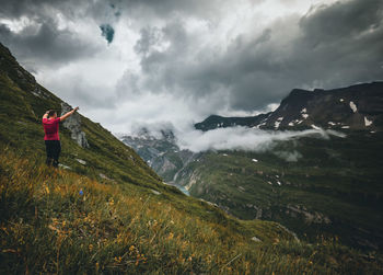 Rear view of man on mountain against sky