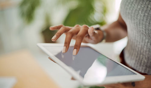 Midsection of woman using digital tablet