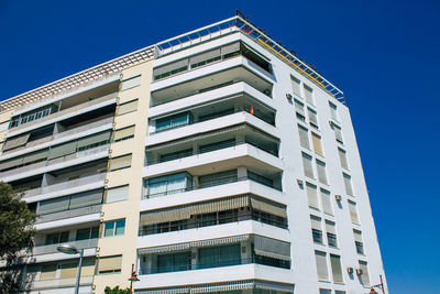 Low angle view of modern building against blue sky